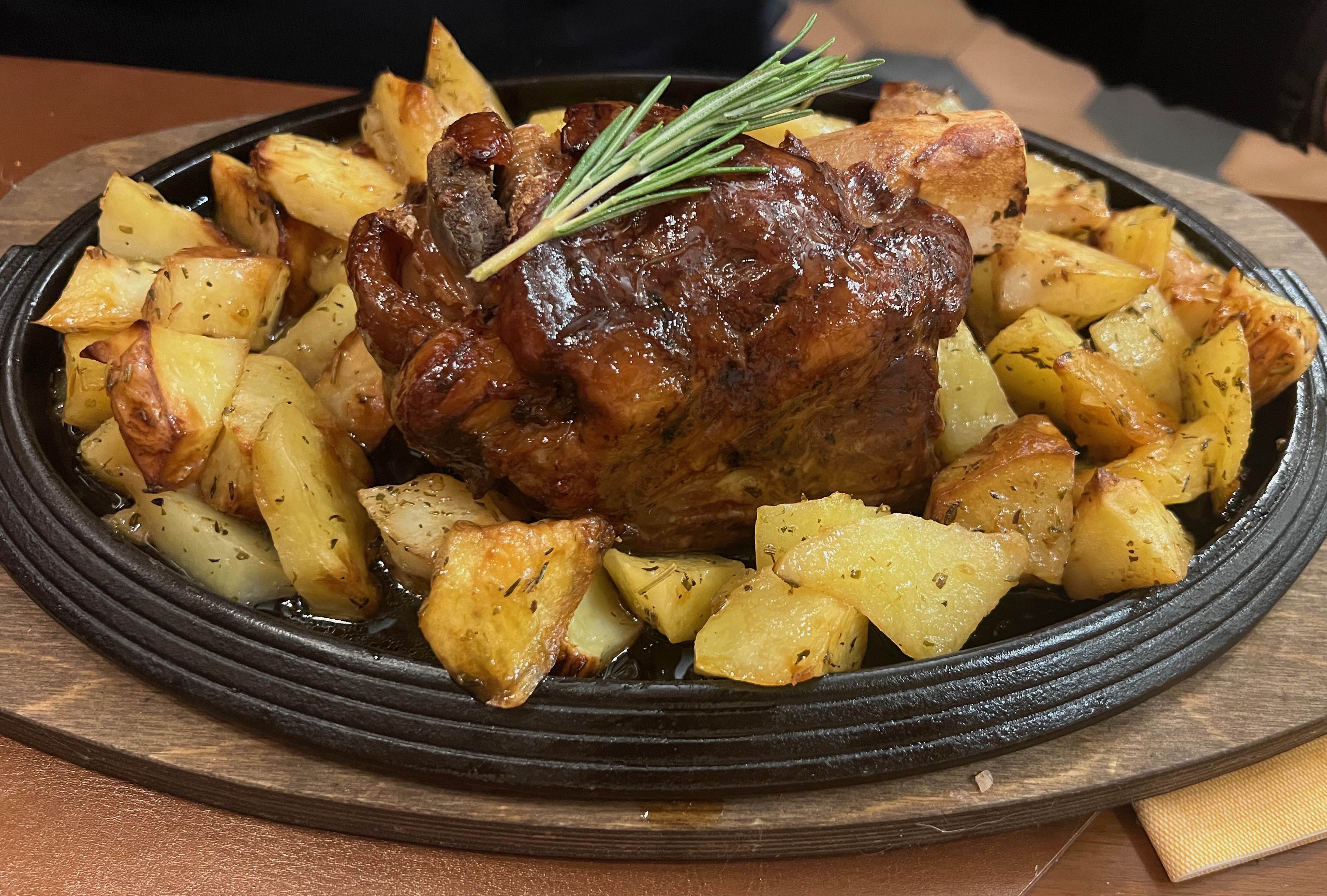 Stinco di maiale alle erbe con patate al forno